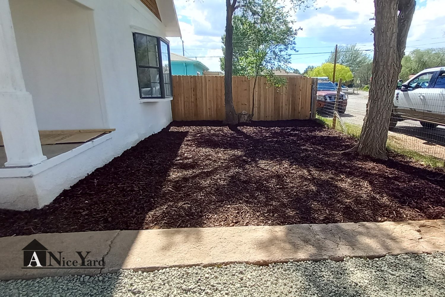 After — Weeds and dirt replaced with clean gravel and mulched beds.